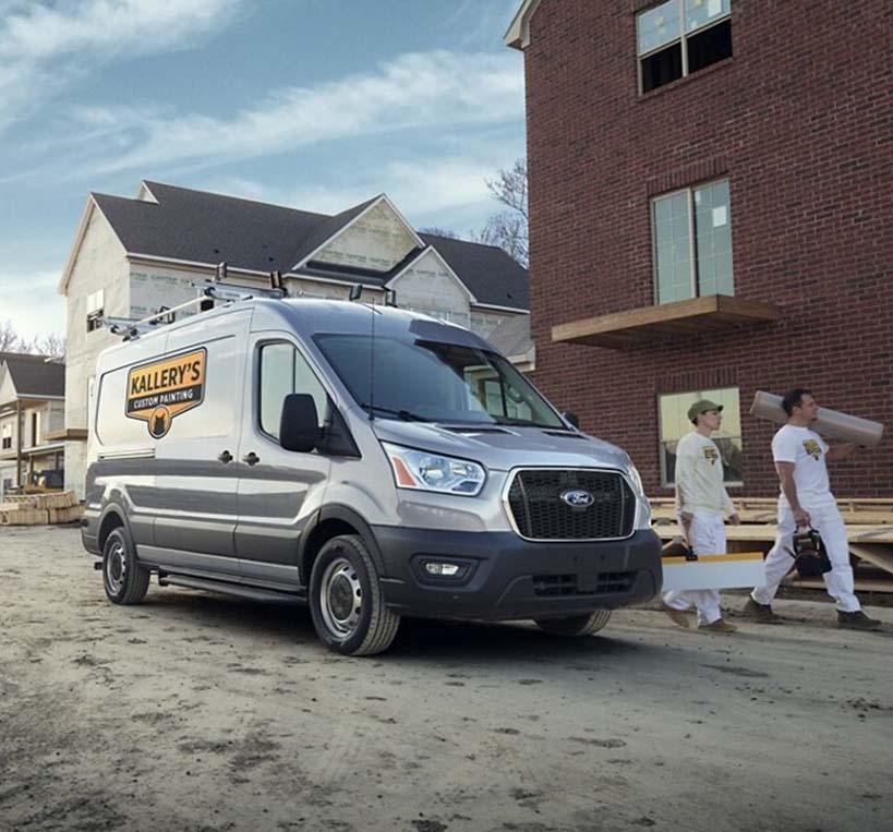 2 workers walking out of their 2022 Ford Transit Passenger Van used for their services