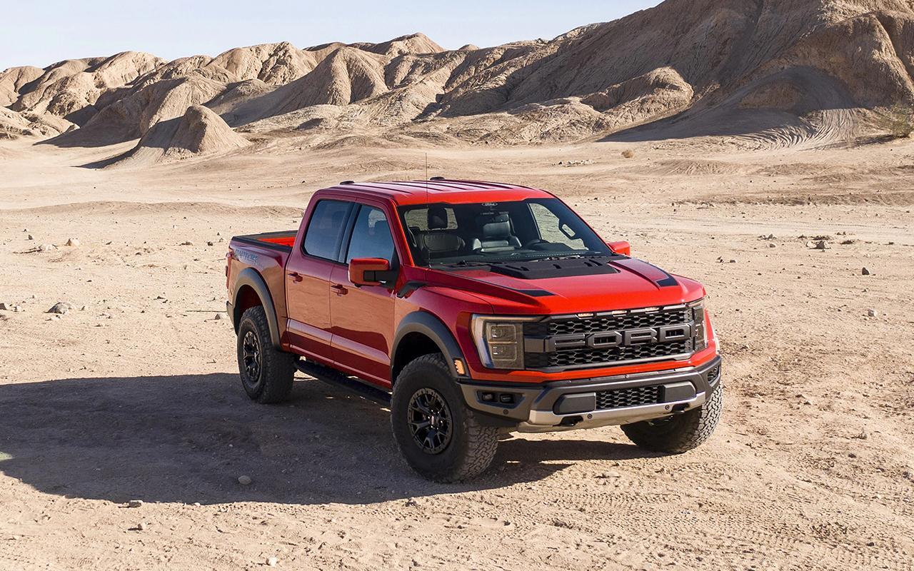 A red 2022 F-150 Raptor® parked in a dessert area next to a mountain