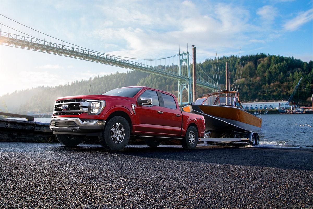 2023 FORD F-150® pulling a boat out of the water in front of a bridge