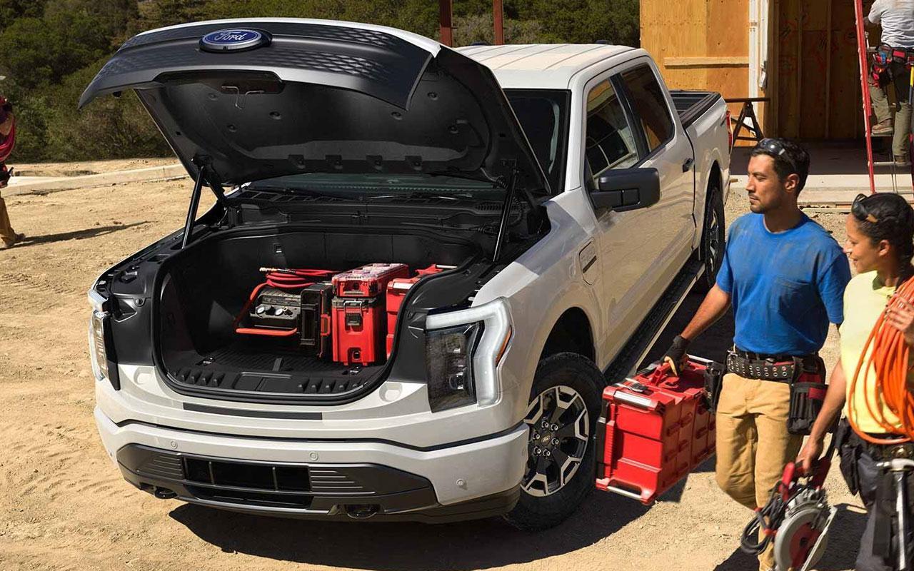 Workers loading up material in the 2022 Ford F-150 Lightning front trunk space