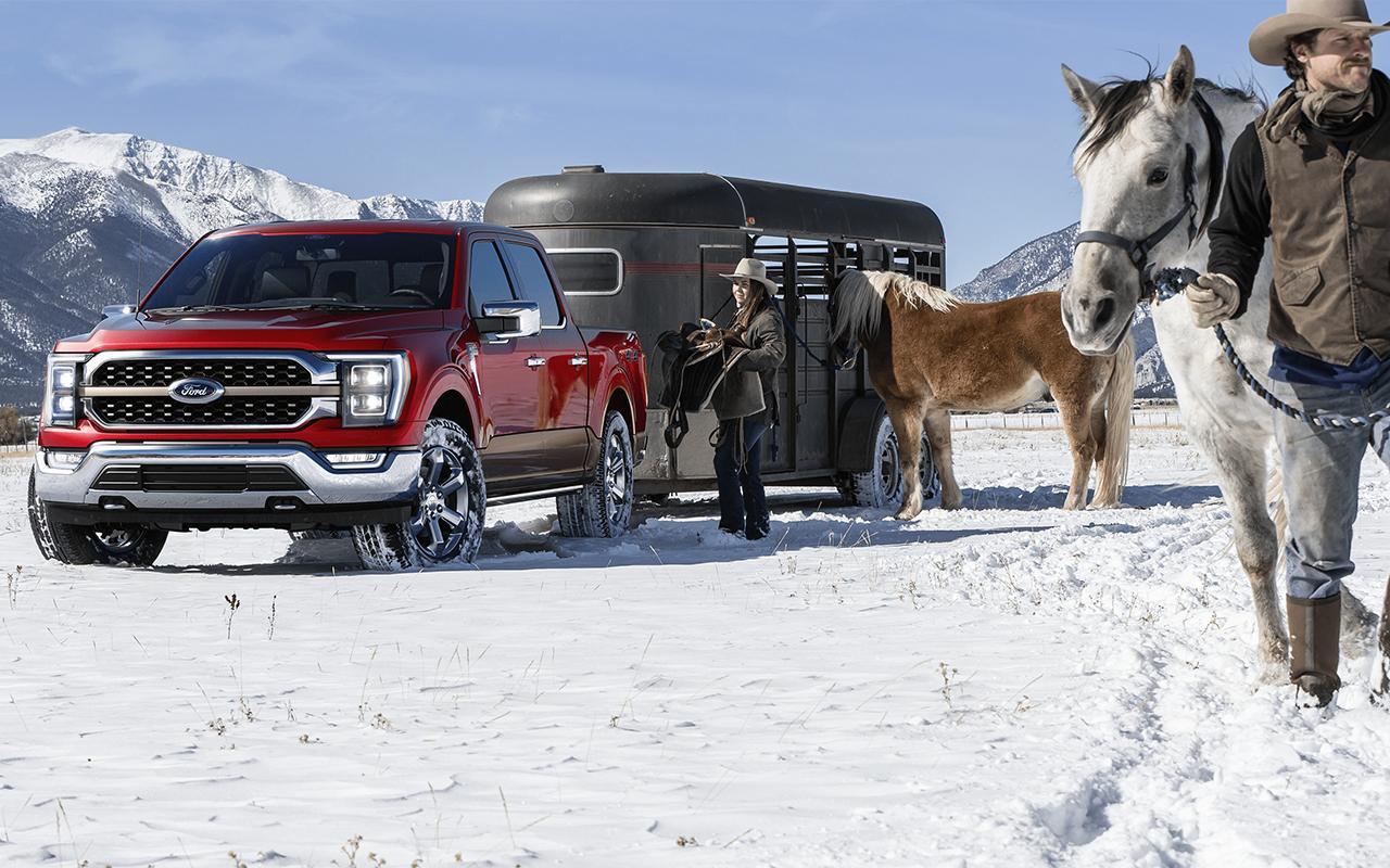 Two cowboys loading up their horse trailer being towed by a 2022 Ford F-150 
