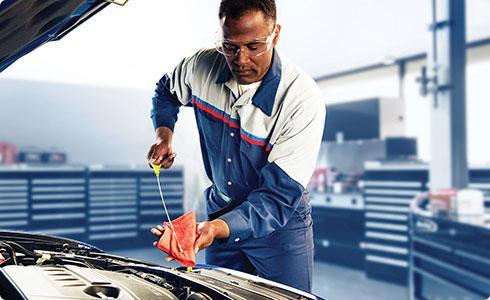 Ford certified technician performing an oil change with synthetic oil