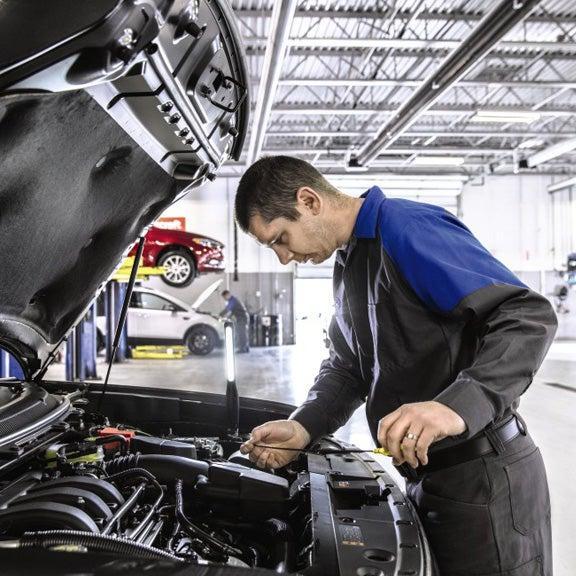 Ford service technician checking fluid levels Ford service technician checking fluid levels