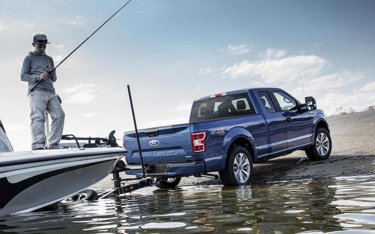 Blue Ford F-150 towing a boat in water