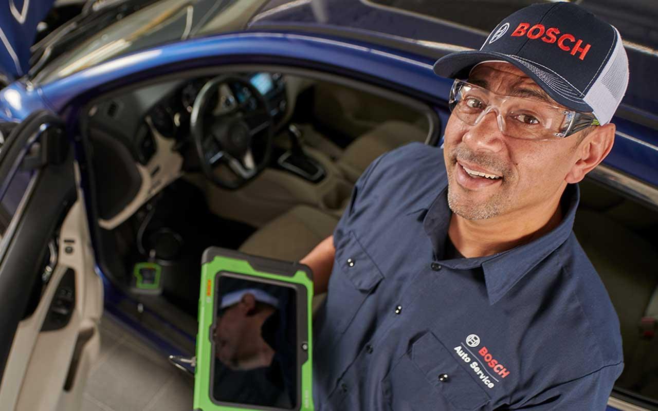 Bosch Auto Service technician running vehicle diagnostics at a service