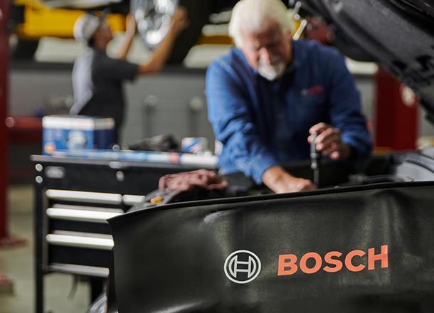 Bosch Auto Service technician running vehicle diagnostics at a service