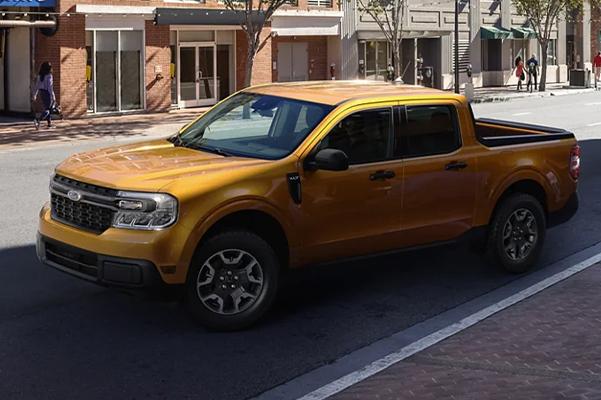 2022 Ford Maverick XLT in Cyber Orange with backup camera parallel parking outside a café