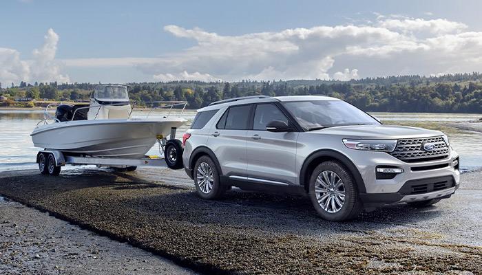 2023 Ford Explorer® Limited model backing a boat on a trailer into a lake