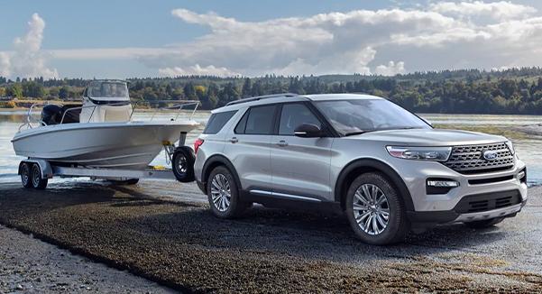 A 2021 Ford Explorer backing a boat and boat trailer into the water