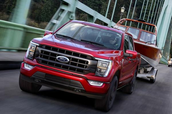 2021 F-150 in red towing boat over bridge